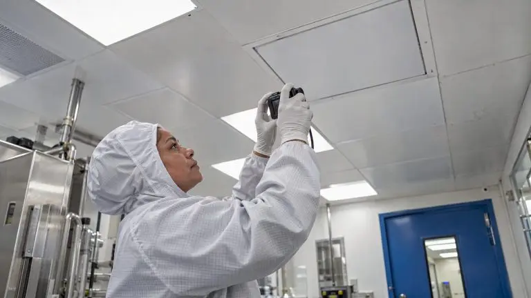 Technician documenting a repaired cleanroom ceiling