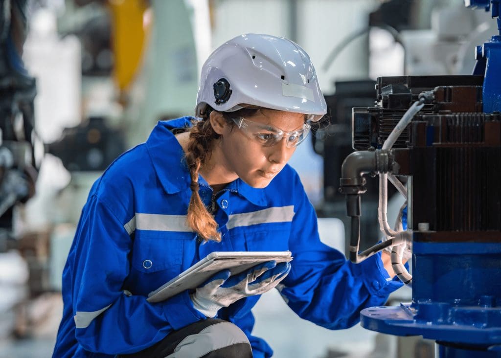 Technician performing preventive maintenance with CMMS software to support PFMEA analysis