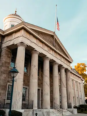 Neoclassical government building with stone columns and an American flag