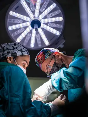 Surgical team working under an operating room light in a hospital