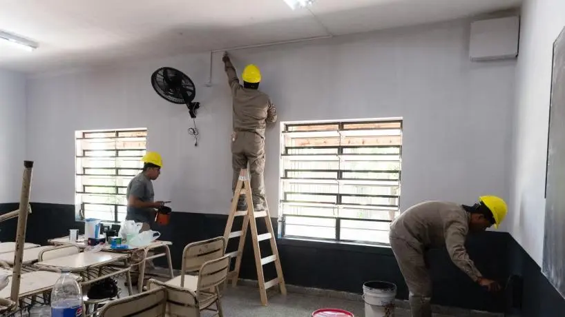 Maintenance crew painting and renovating an empty school classroom during summer break